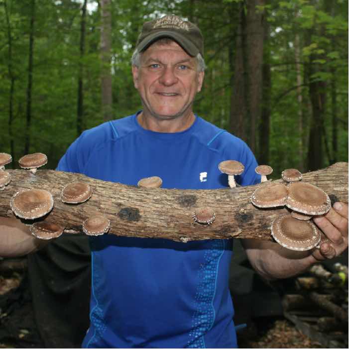 Man holding a shiitake mushroom log